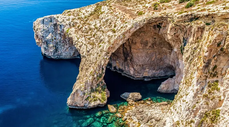 Limestone sea-cave arch on the Malta coastline reached by boat